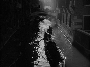 Movie still from “Prince of Foxes” (1949), directed by Henry King – A man is standing on a gondola in the water; Extreme Wide shot, High angle