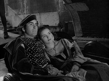 Movie still from “Prince of Foxes” (1949), directed by Henry King – A man and a woman sitting next to each other; Medium shot, High angle