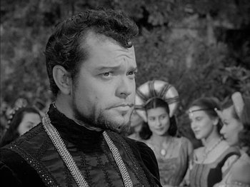 Movie still from “Prince of Foxes” (1949), directed by Henry King – A black and white photo of a man in front of a group of people; Close Up shot, Over the shoulder angle