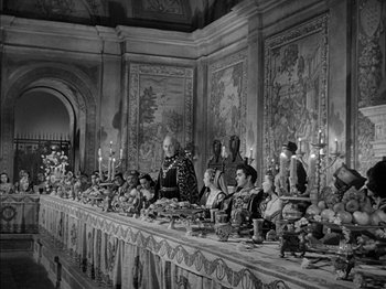 Movie still from “Prince of Foxes” (1949), directed by Henry King – A black and white photo of a table full of people; Wide shot, High angle