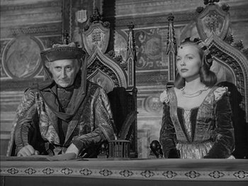 Movie still from “Prince of Foxes” (1949), directed by Henry King – A man and a woman sitting on a chair; Medium shot, High angle