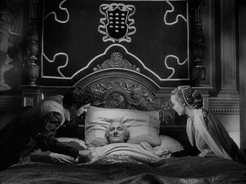 Movie still from “Prince of Foxes” (1949), directed by Henry King – Three people are in a bed with an old man; Wide shot, High angle