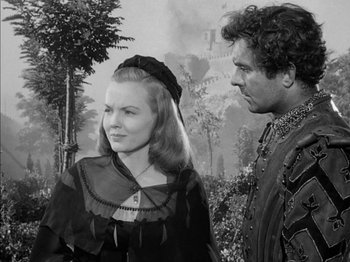 Movie still from “Prince of Foxes” (1949), directed by Henry King – A man and a woman standing next to each other in front of trees; Medium shot, Over the shoulder angle