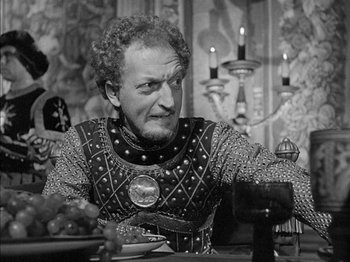 Movie still from “Prince of Foxes” (1949), directed by Henry King – An old man dressed as a knight sitting at a dinner table; Close Up shot, Over the shoulder angle