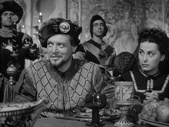 Movie still from “Prince of Foxes” (1949), directed by Henry King – A group of people sitting around a table; Medium shot, Over the shoulder angle
