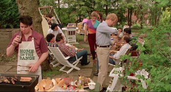 Movie still from “Prince of the City” (1981), directed by Sidney Lumet – A group of people sitting around a table with food on top of it; Wide shot, High angle