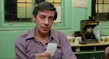 Movie still from “Prince of the City” (1981), directed by Sidney Lumet – A man holding a piece of paper while sitting in a chair; Close Up shot, Over the shoulder angle