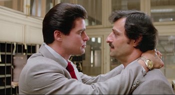 Movie still from “Prince of the City” (1981), directed by Sidney Lumet – Two men in business suits touching each other's hair; Close Up shot, Over the shoulder angle