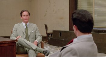 Movie still from “Prince of the City” (1981), directed by Sidney Lumet – A man sitting on a chair in front of another man in a suit; Medium shot, Over the shoulder angle