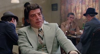 Movie still from “Prince of the City” (1981), directed by Sidney Lumet – A man in a suit and tie sitting in front of another man in a suit and tie; Medium shot, Over the shoulder angle