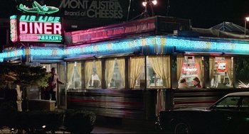 Movie still from “Prince of the City” (1981), directed by Sidney Lumet – A food truck is lit up at night with neon lights; Extreme Wide shot, Low angle