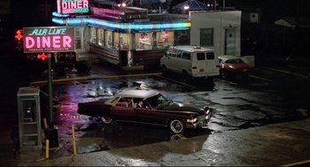Movie still from “Prince of the City” (1981), directed by Sidney Lumet – A car parked on the side of the road at night; Extreme Wide shot, High angle