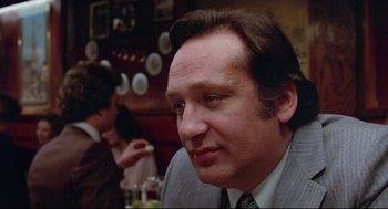 Movie still from “Prince of the City” (1981), directed by Sidney Lumet – A person sitting at a table; Close Up shot, Low angle