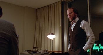 Movie still from “Prince of the City” (1981), directed by Sidney Lumet – A man standing in front of a window in a room; Medium shot, Low angle