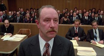 Movie still from “Prince of the City” (1981), directed by Sidney Lumet – A man with a mustache in front of a group of people in a court room; Close Up shot, Low angle