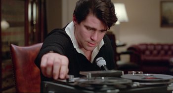 Movie still from “Prince of the City” (1981), directed by Sidney Lumet – A young man in a black shirt is playing a record player; Close Up shot, Low angle