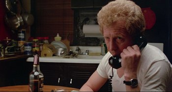 Movie still from “Prince of the City” (1981), directed by Sidney Lumet – A man sitting at a table talking on a phone; Close Up shot, Low angle
