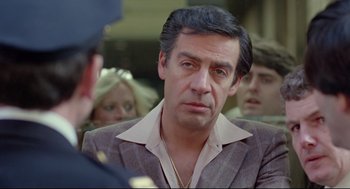 Movie still from “Prince of the City” (1981), directed by Sidney Lumet – A person wearing a suit and tie; Close Up shot, Over the shoulder angle