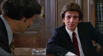Movie still from “Prince of the City” (1981), directed by Sidney Lumet – A man in a suit and tie sitting in front of another man in a suit; Close Up shot, Over the shoulder angle