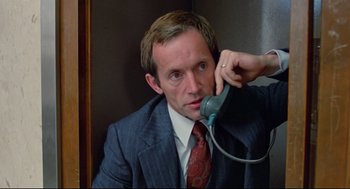 Movie still from “Prince of the City” (1981), directed by Sidney Lumet – A man wearing a suit and tie talking on a phone; Close Up shot, High angle