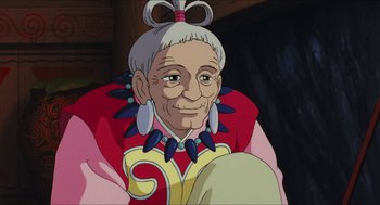 Movie still from “Princess Mononoke” (1997), directed by Hayao Miyazaki – An old woman with a bow in her hair; Close Up shot, Over the shoulder angle