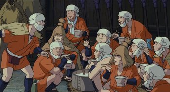 Movie still from “Princess Mononoke” (1997), directed by Hayao Miyazaki – A group of people sitting around a bowl of food; Medium shot, High angle