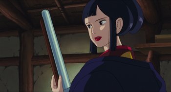 Movie still from “Princess Mononoke” (1997), directed by Hayao Miyazaki – A woman holding a sword while standing next to a wall; Close Up shot, Over the shoulder angle