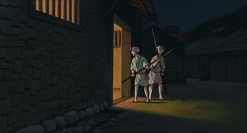 Movie still from “Princess Mononoke” (1997), directed by Hayao Miyazaki – Two men are standing in front of a brick building; Wide shot, Low angle