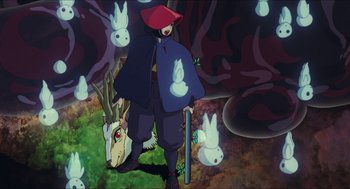 Movie still from “Princess Mononoke” (1997), directed by Hayao Miyazaki – A person standing in front of a bunch of animals; Wide shot, High angle
