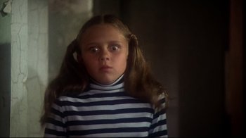 Movie still from “Prom Night” (1980), directed by Paul Lynch – A young girl in a striped shirt with pigtails looking at the camera; Close Up shot, Low angle