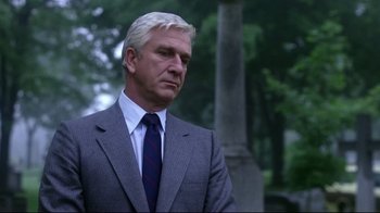 Movie still from “Prom Night” (1980), directed by Paul Lynch – A man in a suit and tie standing next to a tree; Close Up shot, Low angle
