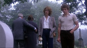 Movie still from “Prom Night” (1980), directed by Paul Lynch – A man and a woman are walking in a cemetery; Medium shot, Low angle