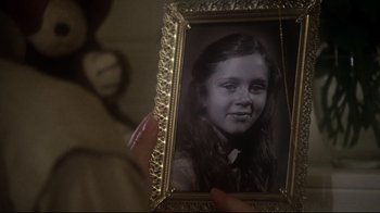 Movie still from “Prom Night” (1980), directed by Paul Lynch – A woman holding a picture of a young girl; Extreme Close Up shot, High angle