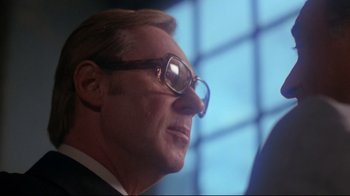 Movie still from “Prom Night” (1980), directed by Paul Lynch – A person wearing glasses and a suit; Close Up shot, Low angle