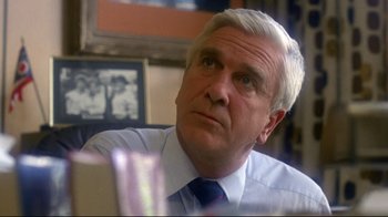 Movie still from “Prom Night” (1980), directed by Paul Lynch – An older man in a white shirt and blue tie; Close Up shot, Low angle