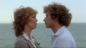 Movie still from “Prom Night” (1980), directed by Paul Lynch – A man and a woman standing next to a body of water; Close Up shot, Low angle