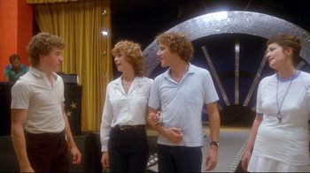 Movie still from “Prom Night” (1980), directed by Paul Lynch – A man and a woman standing next to each other; Wide shot, Over the shoulder angle