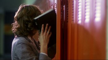 Movie still from “Prom Night” (1980), directed by Paul Lynch – A woman holding an open book up to her face; Medium shot, Low angle
