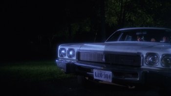 Movie still from “Prom Night” (1980), directed by Paul Lynch – The front end of a parked car at night; Wide shot, High angle