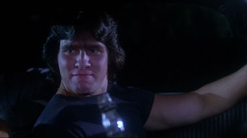 Movie still from “Prom Night” (1980), directed by Paul Lynch – A man holding a bottle in a dark room; Close Up shot, Low angle