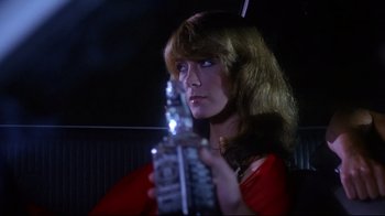 Movie still from “Prom Night” (1980), directed by Paul Lynch – A woman in a car holding a bottle of alcohol; Close Up shot, Over the shoulder angle