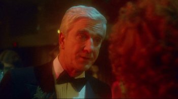 Movie still from “Prom Night” (1980), directed by Paul Lynch – An older man wearing a tuxedo and a bow tie; Close Up shot, Over the shoulder angle