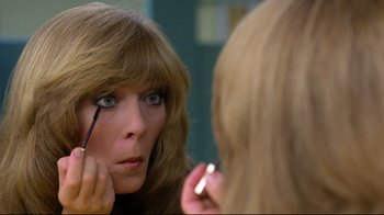 Movie still from “Prom Night” (1980), directed by Paul Lynch – A woman looking in the mirror while putting on makeup; Close Up shot, Over the shoulder angle