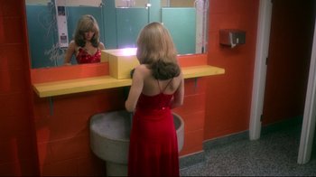 Movie still from “Prom Night” (1980), directed by Paul Lynch – A woman in a red dress looking in a mirror; Medium shot, High angle