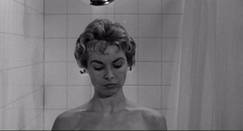 Movie still from “Psycho II” (1983), directed by Richard Franklin – A black - and - white photo of a woman taking a shower; Close Up shot, Low angle