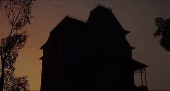 Movie still from “Psycho II” (1983), directed by Richard Franklin – A building that has been lit up in the dark; Extreme Wide shot, Low angle