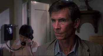 Movie still from “Psycho II” (1983), directed by Richard Franklin – A person in a room near a door; Close Up shot, Low angle
