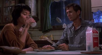 Movie still from “Psycho II” (1983), directed by Richard Franklin – A man and a woman sitting at a table with a knife; Medium shot, Low angle