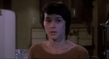 Movie still from “Psycho II” (1983), directed by Richard Franklin – A woman with short black hair wearing a brown sweater; Close Up shot, Over the shoulder angle