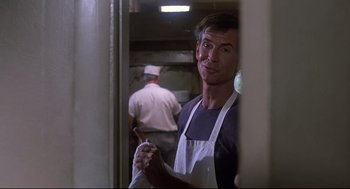 Movie still from “Psycho II” (1983), directed by Richard Franklin – A man wearing an apron standing in a kitchen; Close Up shot, Low angle